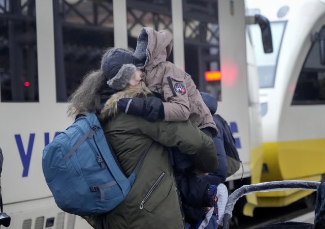 Chlapec se objímá se svým otcem na vlakovém nádraží v Kyjevě předtím, než jej vlak odveze v rámci evakuace z hlavního a ruskou armádou ostřelovaného města Ukrajiny.