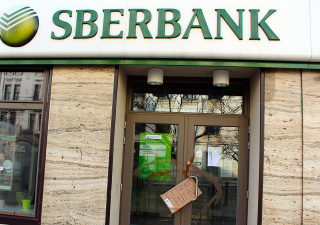 Uzavřená pobočka ruské banky Sberbank s barvou potřísněnými dveřmi a výlohami na Strossmayerově náměstí v Praze 26. února 2022.