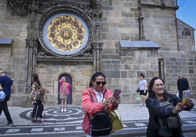 Turisté se fotí před orlojem na Staroměstském náměstí v Praze