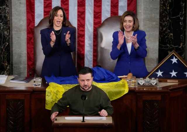 Ukrajinský prezident Volodymyr Zelenskyj v americkém Kongresu 21. prosince 2022. Před viceprezidentkou Kamalou Harrisovou a šéfkou americké Sněmovny reprezentantů Nancy Pelosiovou leží ukrajinská vlajka s podpisy vojáků z osvobozeného ukrajinského města Bachmut.