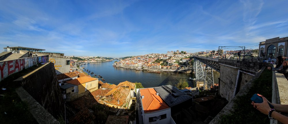 Porto - slavné nábřeží Cais Da Ribeira a střechy vinných sklepů ve čtvrti Vila Nova de Gaia. Zcela vlevo je betonová stanice lanovky.