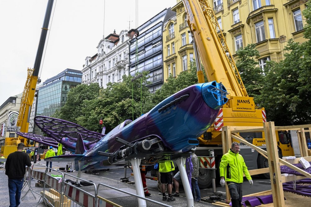 Na obchodní dům Máj na pražské Národní třídě dělníci instalují několikametrové motýly od výtvarníka Davida Černého s trupem napodobujícím stíhačku spitfire