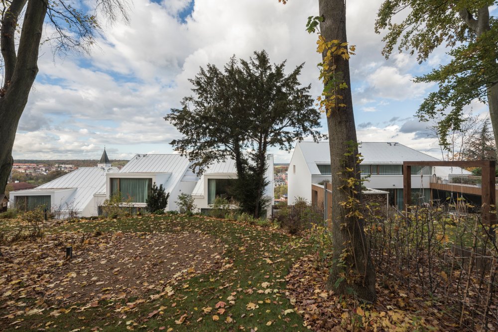 Prudce se svažující zahrada na skále nad domy je více divoká a využívá původní vzrostlou vegetací.