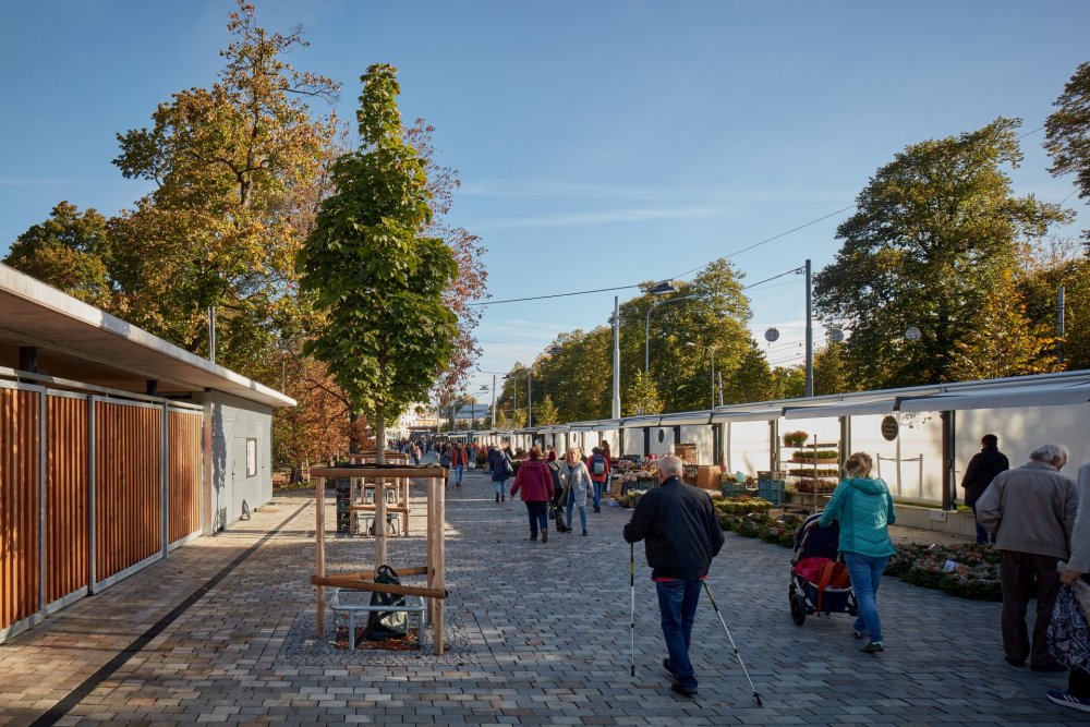 Při navrhování museli architekti ze studia ellement architects zohlednit požadavky památkové péče, městské zeleně a uživatelů a majitelů stávajících prodejních budek, které nebyly součástí projektu rekonstrukce.