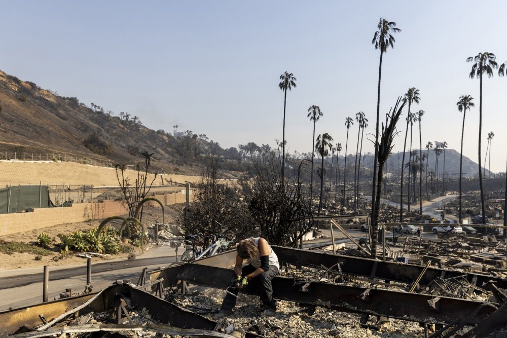  Můž hledá věci v domě své přítelkyně, který zničil požár v Pacific Palisades.