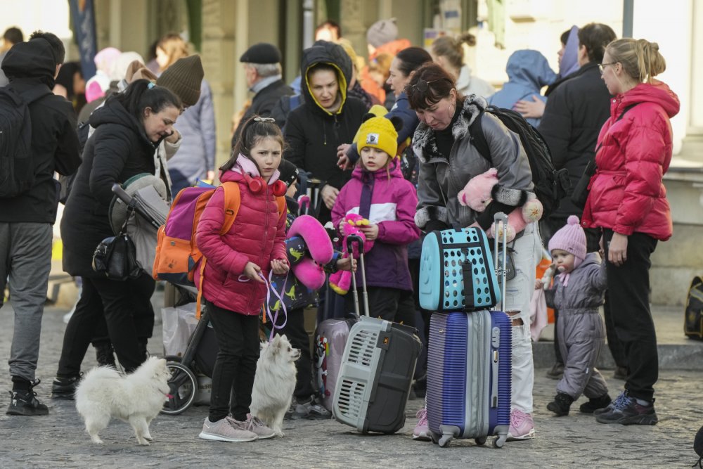 Děti a dospělí utíkající před válkou z Ukrajiny čekají na vlakovém nádraží v polské Přemyšli na odvoz, 24. března 2022