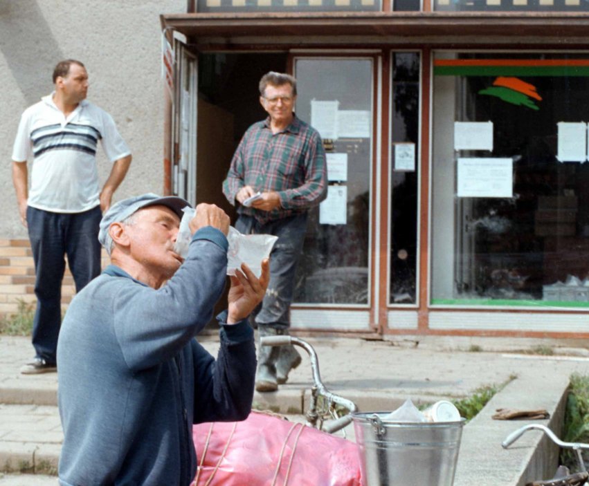 Obyvatel Troubek pije vodu ze sáčku od francouzských specialistů civilní obrany, kteří pomocí mobilní čistírny upravovali užitkovou vodu na pitnou. (24.7.1997)