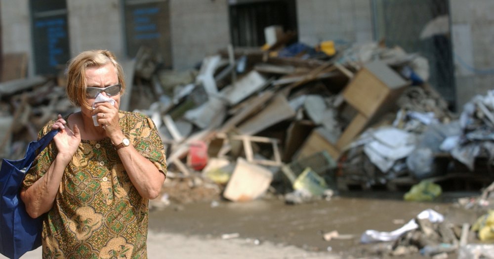 Žena si chrání dýchací cesty 26. srpna 2002 v pražském Karlíně. Důvodem je zápach linoucí se ze zaplavených a poničených domů po povodních dva týdny předtím..