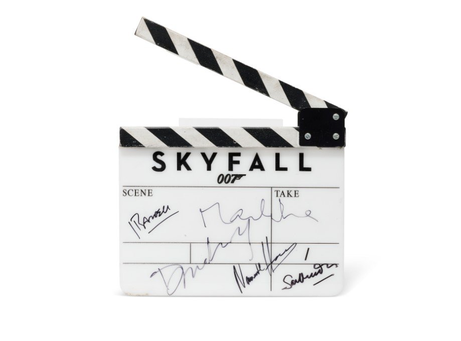 Filmová klapka k filmu Skyfall (2012), podepsaná Samem Mendesem, Danielem Craigem, Bérenice Marloheovou, Naomie Harrisovou a Javierem Bardemem, odhadovaná cena pět až sedm tisíc liber.