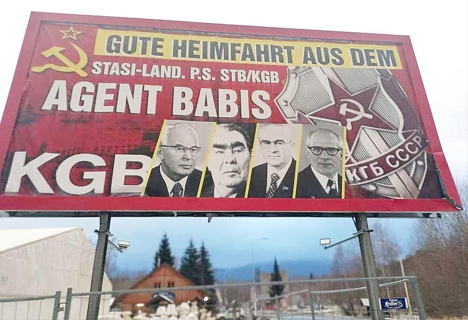 Tento billboard visí na hranicích mezi Železnou Rudou a obcí Bayrisch Eisenstein. "Přejeme vám bezpečnou jízdu domů do Německa ze země agenta StB Babiše."