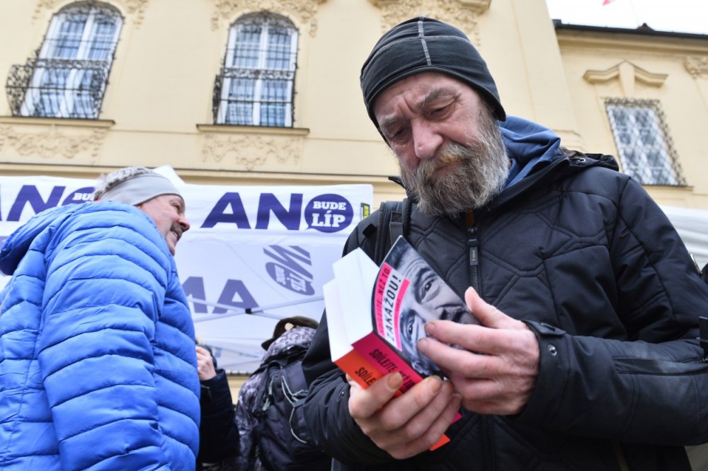 Muž listuje knihou prezidentského kandidáta Andreje Babiše na setkání Babiše s občany, 23. ledna 2023 v Brně.