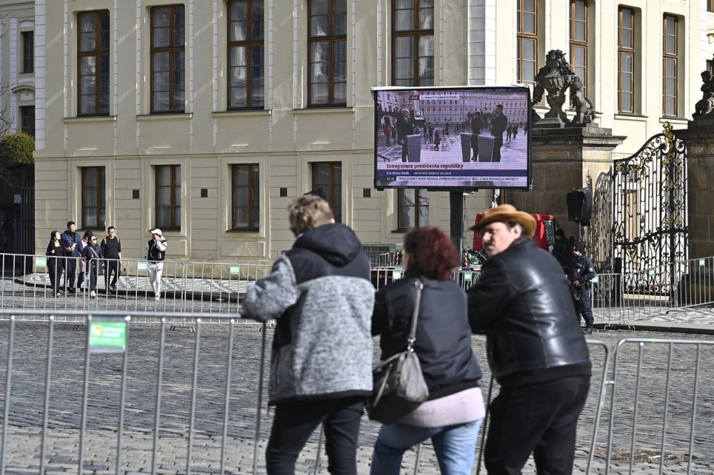 Inaugurace nově zvoleného prezidenta Petra Pavla, 9. března 2023, Pražský hrad. Lidé na Hradčanském náměstí sledují na velkoplošné obrazovce televizní přenos z dění před začátkem inaugurace.