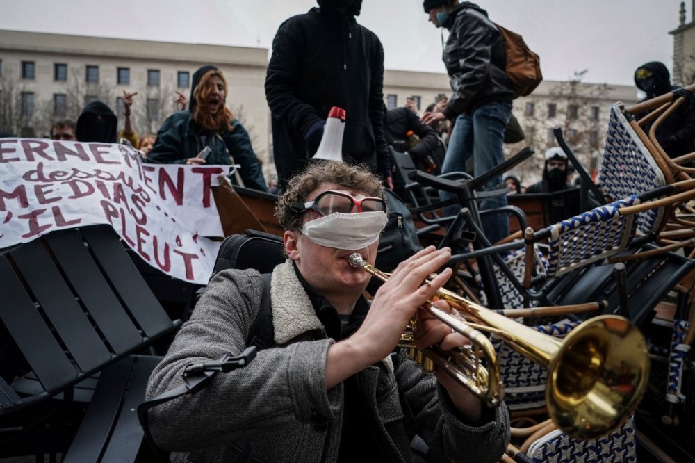 Nejen dělobuchy. Francii v týdnu zasáhla vlna demonstrací proti důchodové reformě. Na rozdíl od některých agresivních protestujících zvolil muž hraní na trubku, a to před barikádou během demonstrace v Lyonu v úterý 7. března 2023.