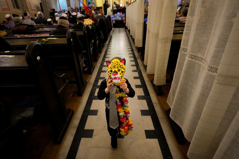 Svátek Purim. Dítě si upravuje leopardí masku během svátku Purim, který slavila rumunská židovská komunita v synagoze Coral Temple v Bukurešti, Rumunsko, pondělí 6. března 2023.