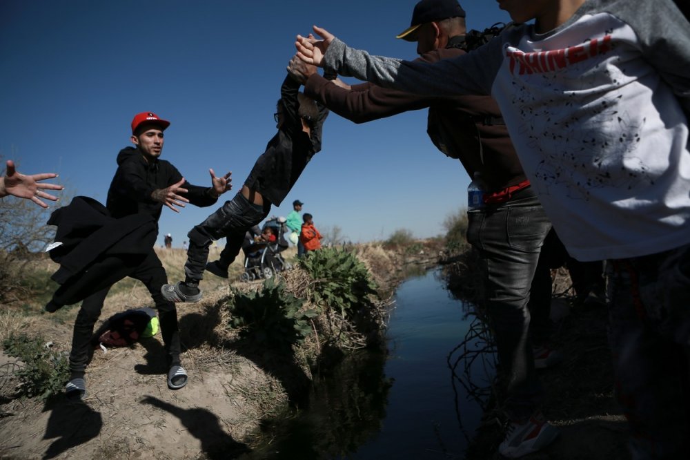 Migranti překračují řeku Rio Grande ve snaze přejít z mexického Ciudad Juarez do Spojených států 29. března 2023. Snímek byl pořízen den poté, co desítky migrantů zemřely při požáru v záchytném středisku pro migranty v Ciudad Juarez. 