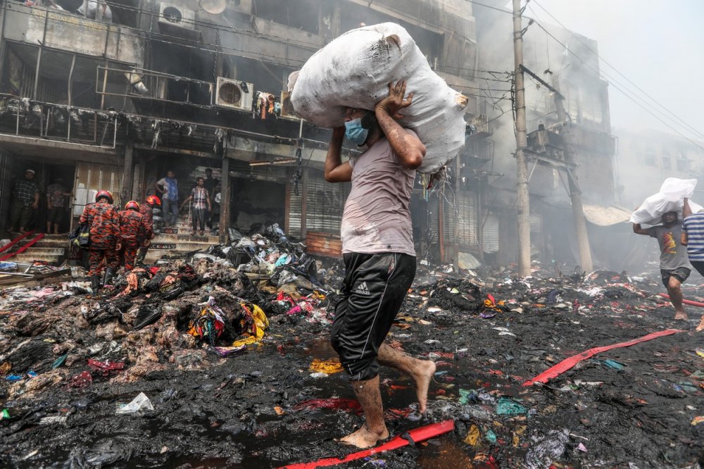 Obchodníci zachraňují své zboží z obchodů při požáru na oblíbeném trhu s levným oblečením v bangladéšském hlavním městě Dháce, úterý 4. dubna 2023. Požár vypukl na trhu Bangabazar v Dháce v úterý 4. dubna..