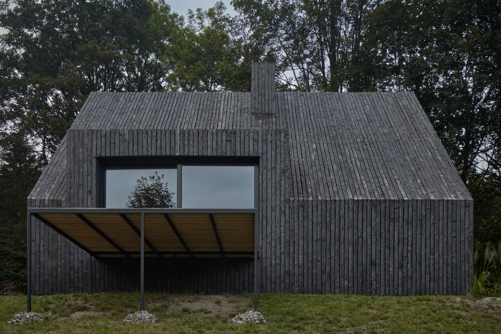 Stavba s brizolitovou fasádou potřebovala opravit zvenčí i uvnitř. Architekti ze studia Mjölk se rozhodli zabalit stávající budovu do pláště z opalovaných prken.