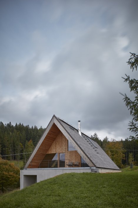 Dům podle návrhu architektů z Pavel Míček Architects stojí uprostřed téměř nezastavěné horské krajiny. Samotný pozemek z horní strany přiléhá ke zpevněné cestě a je tvořen divokou horskou loukou padající až do zalesněného, stinného žlebu s protékajícím potokem.