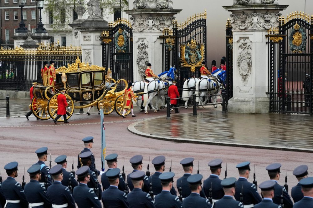 Do Buckinghamského paláce vjíždí zlatem zdobený kočár nazvaný The Diamond Jubilee State Coach tažený šesti koňmi, který byl vyroben na památku 80. narozenin královny Alžběty II. 