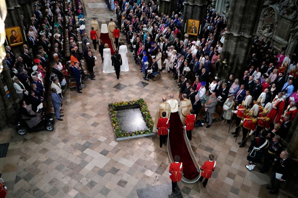 Král Karel III. (s dlouhým fialovým pláštěm) vstupuje do Westminster Abbey.