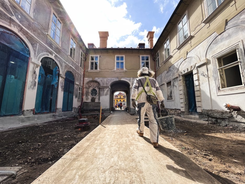 Odstraněním budov někdejších tiskáren se obnoví prostor mezi původním barokním palácem a historickou jízdárnou, která kdysi byla součástí barokního půdorysu. (na snímku je první "nádvoří" směrem od ulice Na Příkopě)