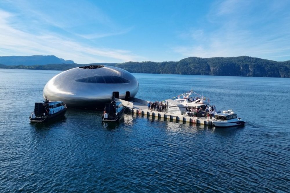 Oko lososa (Salmon Eye) v norském fjordu Hardangerfjord - Tvarově se má se svým oválným tvarem blížit oku opravdového lososa a svou a stříbřitou fasádou pak lososí kůži. 