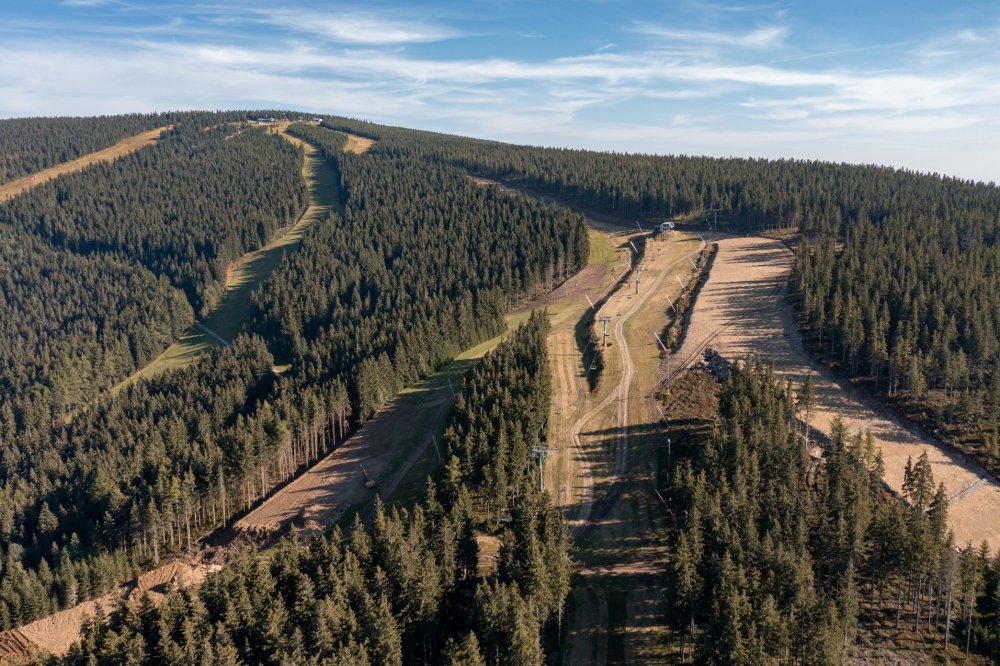 Pohled na sjezdovky u horní stanice lanovky Hromovka. Vpravo je vidět začátek nové sjezdovky Přehradní, po levé straně pak rozšiřované úseky oblíbené modré sjezdovky